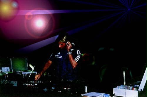 DJ Manni Bel live am Mischpult mit Lasershow im Hintergrund